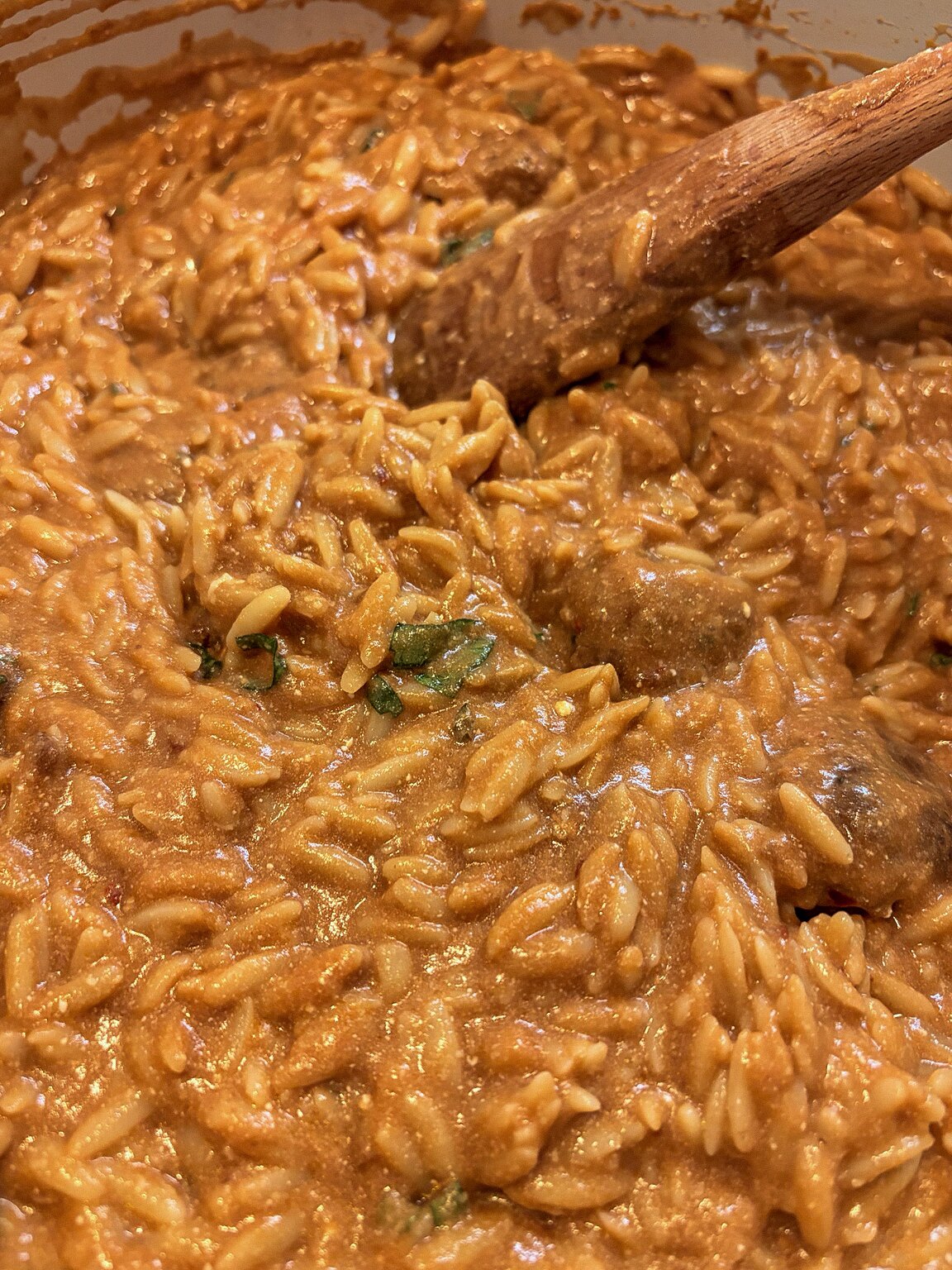 Pomodoro basil orzo soup and meatballs cooking in a pot